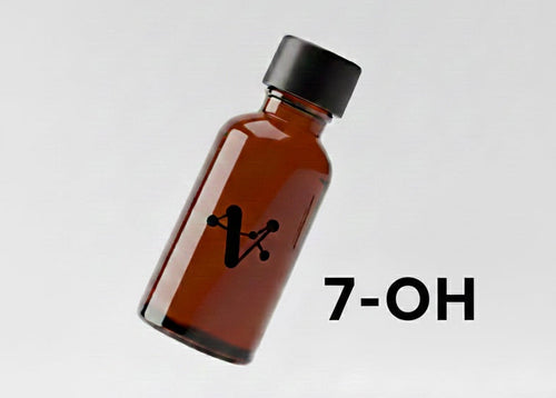 Amber glass bottle with black cap on a light gray background